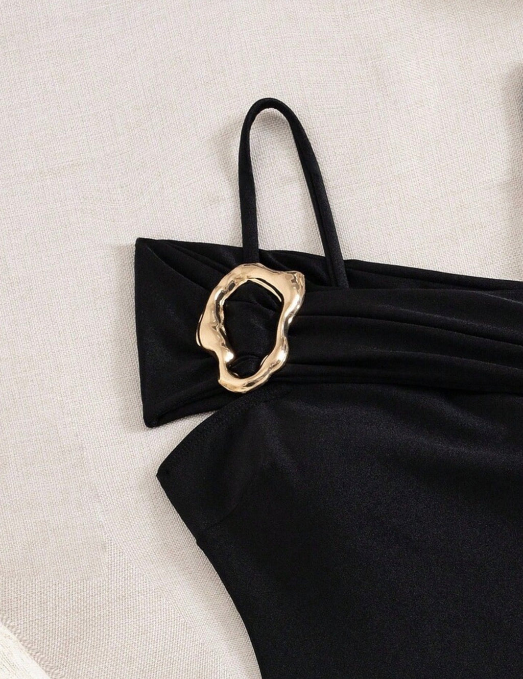Vista frontal traje de baño negro una pieza con tirantes y detalle metálico