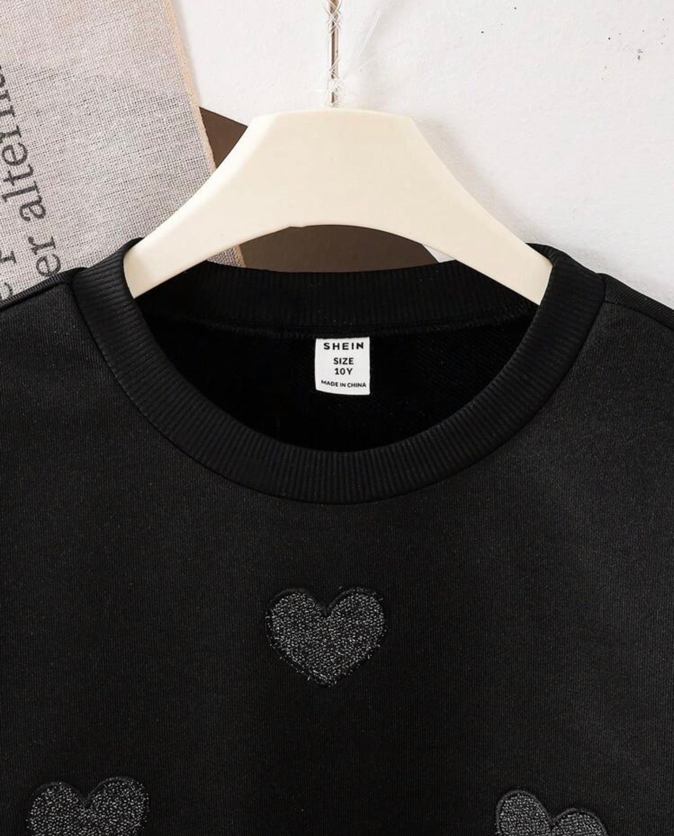 Detalle parche corazon brillante sudadera negra nina