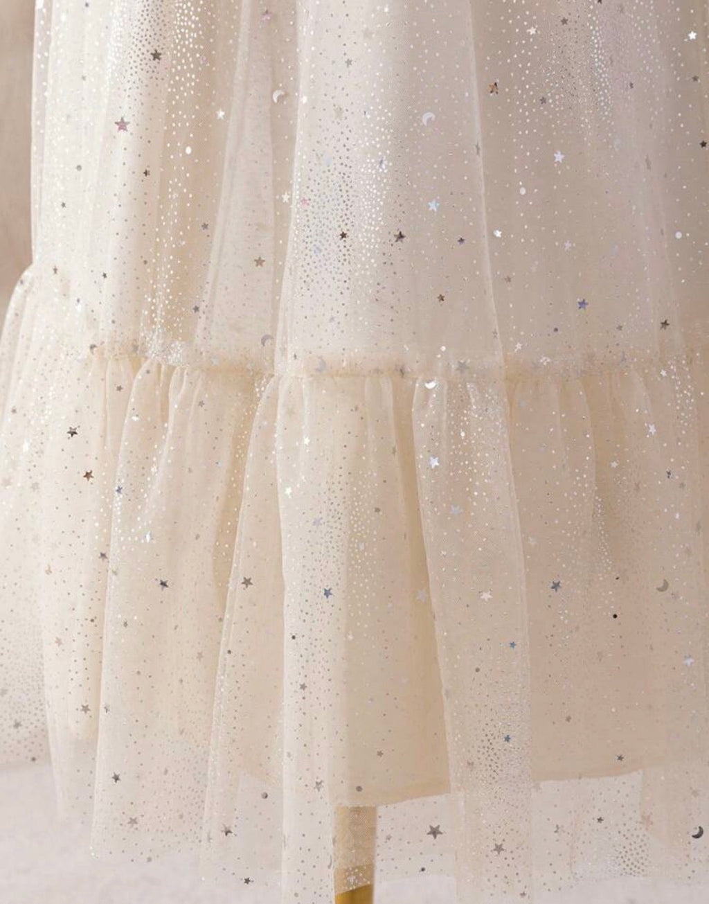 Detalle tul con estrellas y lunas plateadas en la falda
