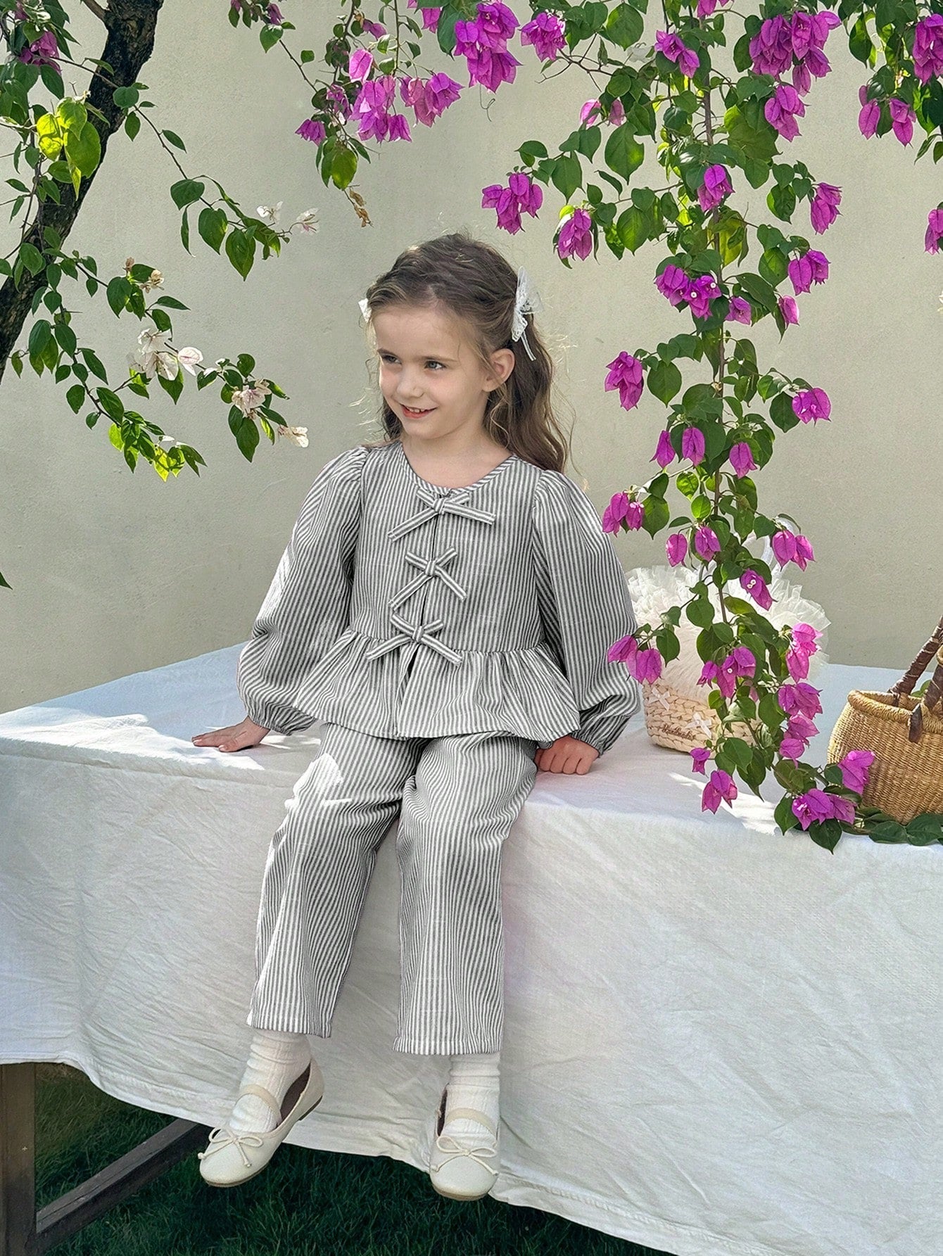 Niña usando conjunto de rayas blusa con lazos y pantalón pierna ancha