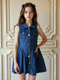 Niña usando vestido vaquero azul sin mangas con botones dorados